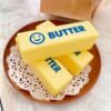 Slow-rise squishy toy shaped like a realistic butter stick, made by NeeDoh